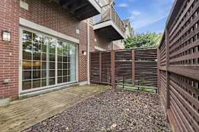 A patio area with a brick wall and a wooden fence.