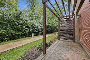 A wooden pergola over a brick walkway.