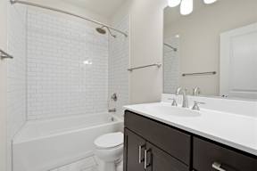 A white bathroom with a toilet, sink, and bathtub.