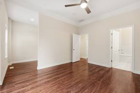 A room with wooden floors and a ceiling fan.