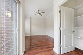 A room with a ceiling fan and a door.