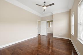 A room with a ceiling fan and wooden floors.