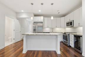 A kitchen with white cabinets and a granite countertop.