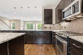 A kitchen with dark wood cabinets and stainless steel appliances.