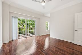 A room with a sliding glass door leading to a balcony.