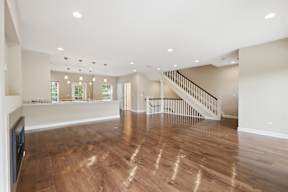 A spacious living room with a staircase and a television.