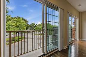 A balcony with a view of a street and trees.