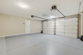 A garage with a white floor and a white door.