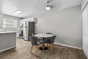 A kitchen with a dining table and chairs.