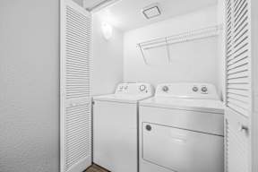 A white laundry room with a washer and dryer.
