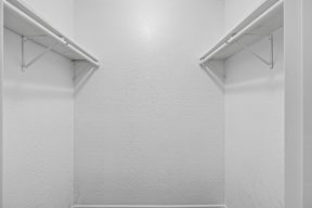 Two white shelves on a white wall.