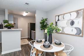 an open kitchen and dining area with a table and plants