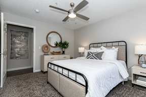 a bedroom with a bed and a ceiling fan