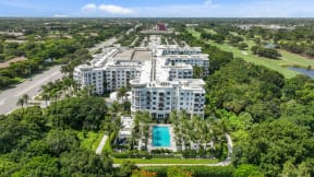 an aerial view of a building surrounded by trees and a pool