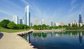 A city skyline is reflected in the water.