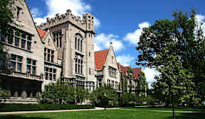 A large building with a red roof and a green lawn in front.