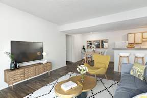 A living room with a television, a yellow chair, and a coffee table.