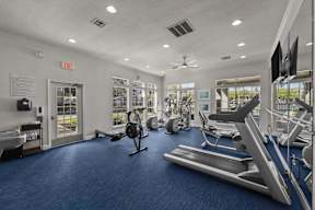 A gym with a variety of equipment including treadmills, exercise bikes, and weight machines.