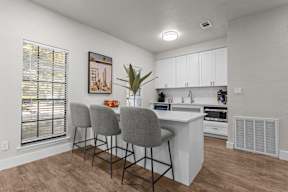 A kitchen with white cabinets and a wooden floor.
