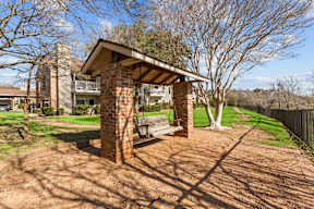 A house with a covered patio and a brick chimney.