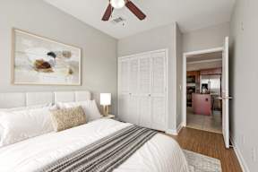A bedroom with a large bed and a painting on the wall.