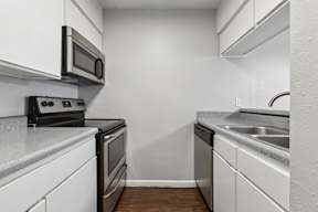 A kitchen with white cabinets and a black stove top oven.