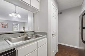 A kitchen with a sink and a refrigerator.