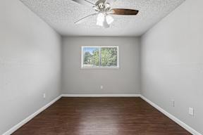 Empty room with a ceiling fan and a window.