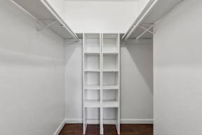 A white shelving unit in a white room.