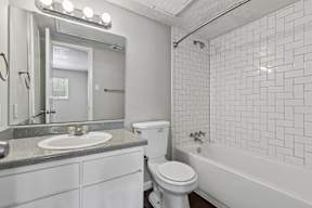 A white bathroom with a sink, toilet, and bathtub.