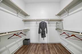 A closet with a grey coat hanging in the middle.