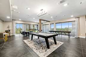 A spacious room with a pool table and a view of the outside.