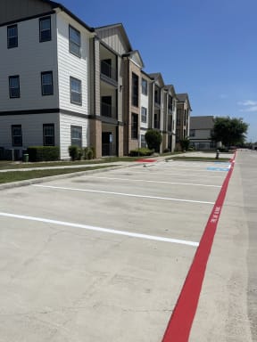 an empty parking lot in front of an apartment building