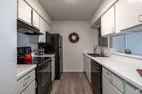 a kitchen with white cabinets and black appliances