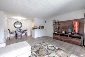 a living room with a couch and a table in a kitchen
