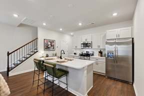 A kitchen with a white counter top and a stainless steel refrigerator.