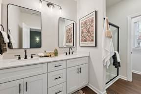 A bathroom with two sinks and a large mirror.