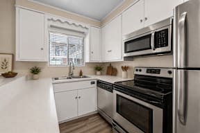 A modern kitchen with stainless steel appliances and white cabinets.