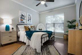 a bedroom with a bed and a ceiling fan