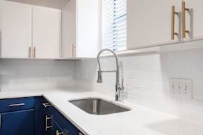 white counter tops with blue cabinets in the kitchen