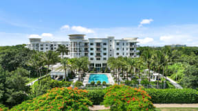 a view of the resort with a pool and palm trees