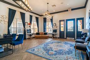 a living room with blue curtains and a blue rug and a piano