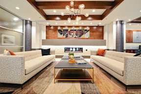 A modern living room with a glass coffee table and two couches.