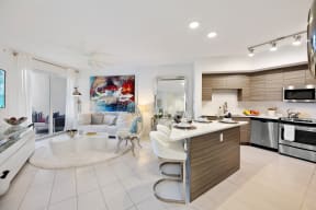 a living room with a couch and a kitchen with a sink