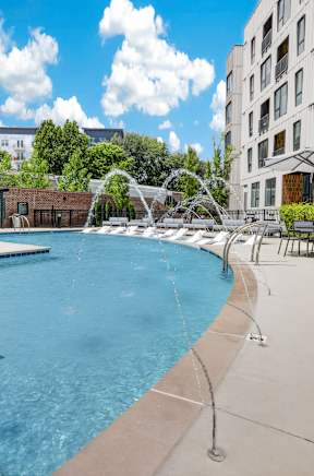 A pool with a fountain in the middle of it.