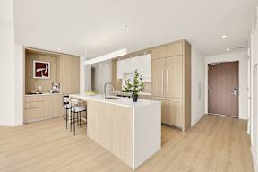 A kitchen with a white island and wooden floors.