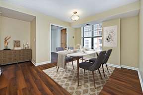 A dining room with a table and chairs.