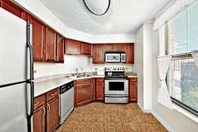 A kitchen with brown cabinets and white appliances.