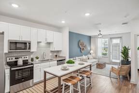 A modern kitchen with a dining table set for two.