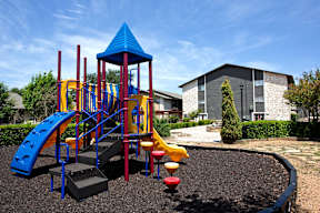 a playground at a school with a building in the background